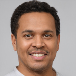 Joyful latino young-adult male with short  brown hair and brown eyes