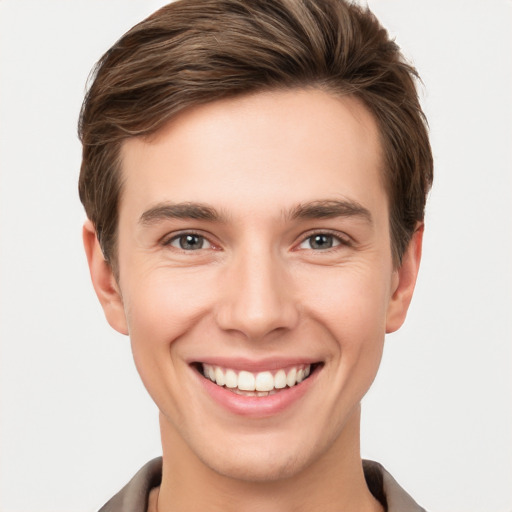 Joyful white young-adult male with short  brown hair and grey eyes