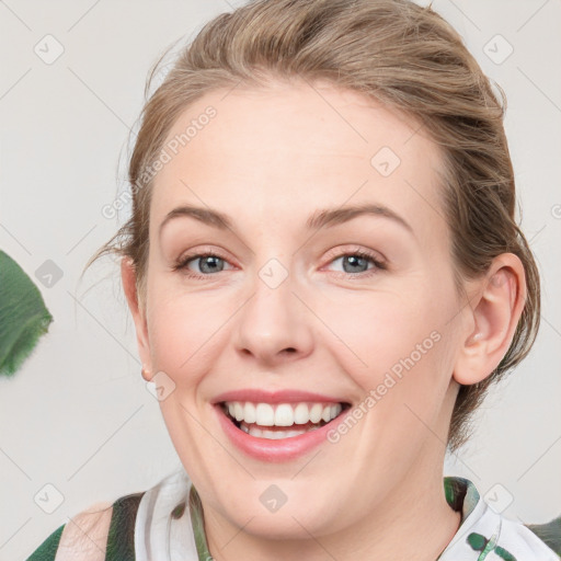 Joyful white young-adult female with medium  brown hair and green eyes