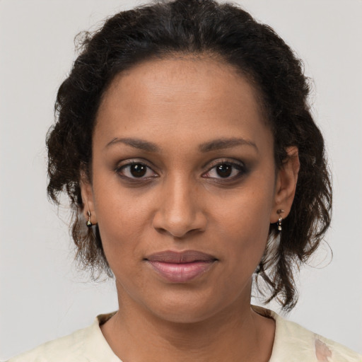 Joyful black young-adult female with medium  brown hair and brown eyes