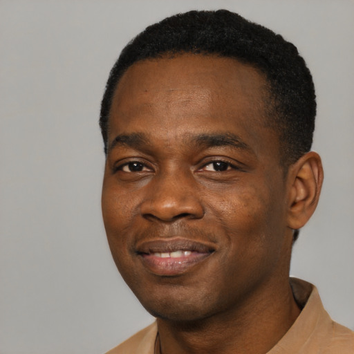 Joyful black young-adult male with short  black hair and brown eyes