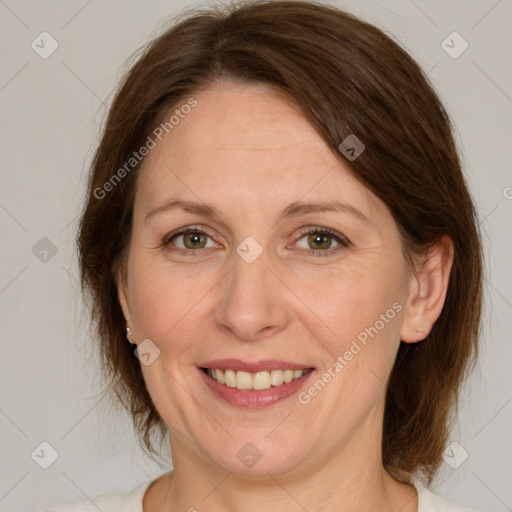 Joyful white adult female with medium  brown hair and green eyes