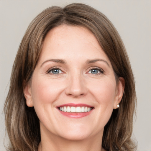 Joyful white adult female with medium  brown hair and grey eyes