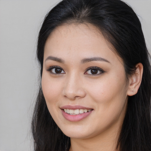 Joyful asian young-adult female with long  brown hair and brown eyes