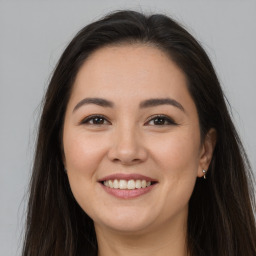 Joyful white young-adult female with long  brown hair and brown eyes