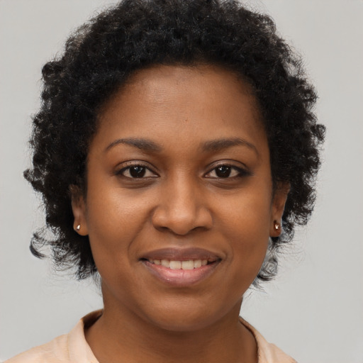 Joyful black young-adult female with short  brown hair and brown eyes