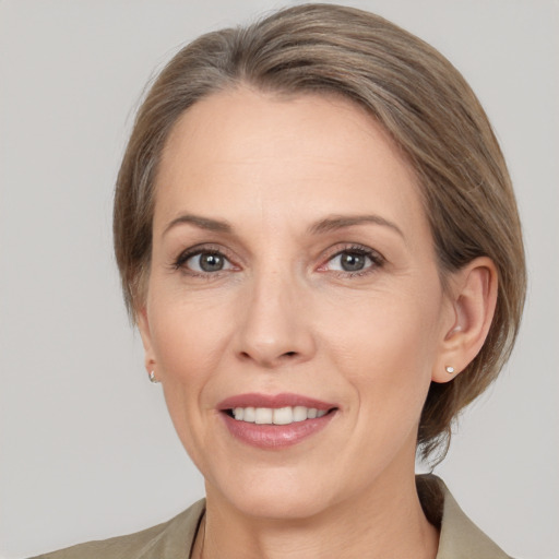 Joyful white adult female with medium  brown hair and grey eyes