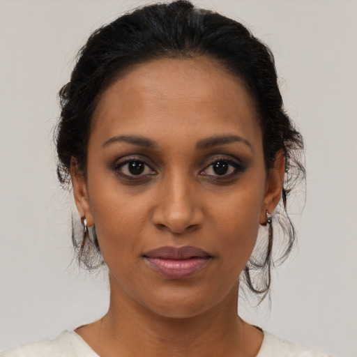 Joyful black young-adult female with medium  brown hair and brown eyes