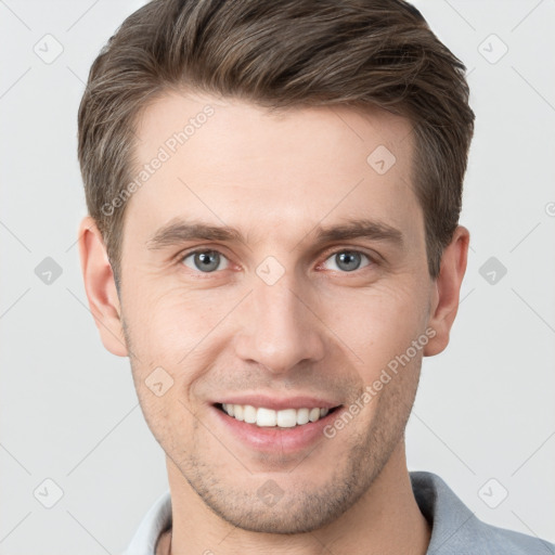 Joyful white young-adult male with short  brown hair and grey eyes