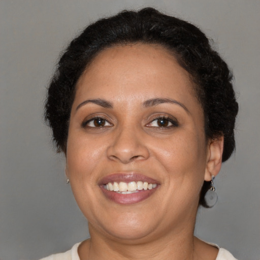 Joyful black adult female with short  brown hair and brown eyes