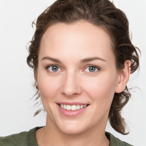 Joyful white young-adult female with medium  brown hair and green eyes