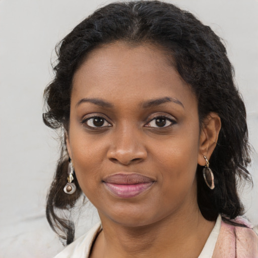 Joyful black young-adult female with long  brown hair and brown eyes