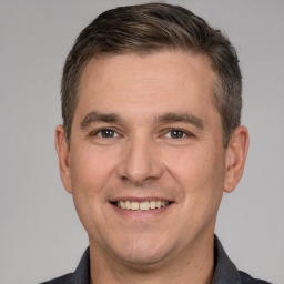 Joyful white young-adult male with short  brown hair and brown eyes