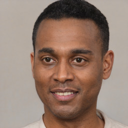 Joyful black young-adult male with short  black hair and brown eyes