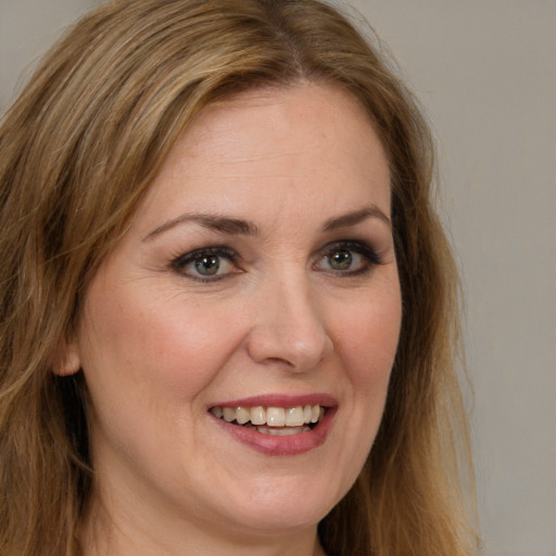 Joyful white adult female with long  brown hair and brown eyes