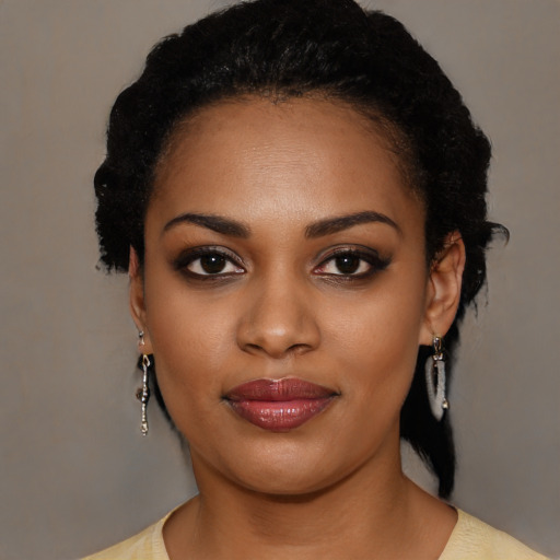 Joyful black young-adult female with long  black hair and brown eyes