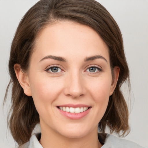 Joyful white young-adult female with medium  brown hair and green eyes