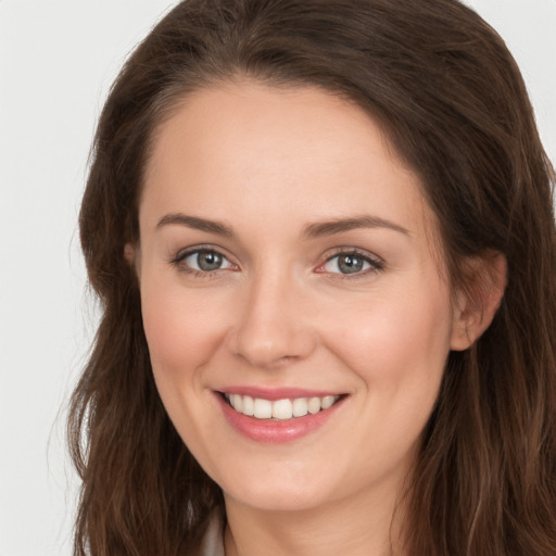 Joyful white young-adult female with long  brown hair and grey eyes