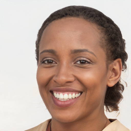 Joyful black young-adult female with long  brown hair and brown eyes