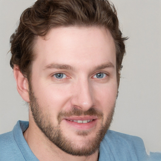 Joyful white young-adult male with short  brown hair and blue eyes