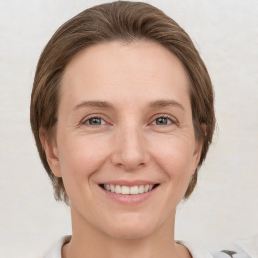 Joyful white adult female with short  brown hair and grey eyes