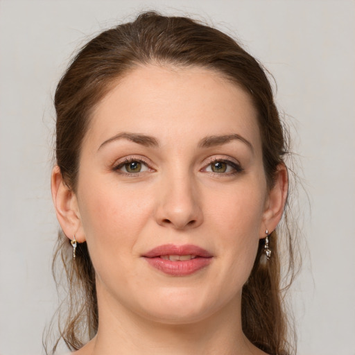 Joyful white young-adult female with medium  brown hair and green eyes