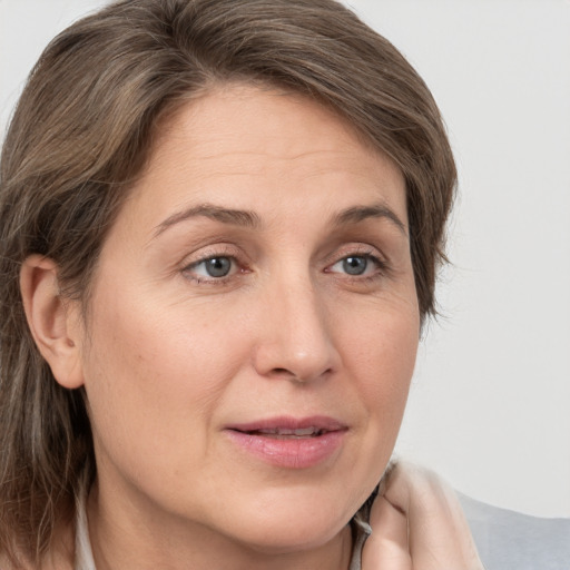 Joyful white adult female with medium  brown hair and grey eyes