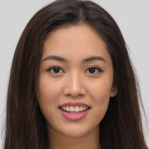 Joyful asian young-adult female with long  brown hair and brown eyes