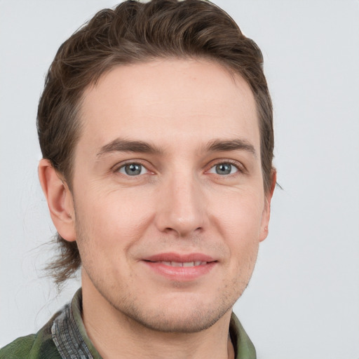 Joyful white young-adult male with short  brown hair and grey eyes