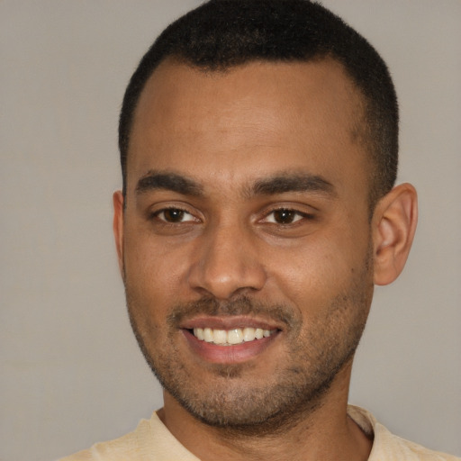 Joyful black young-adult male with short  brown hair and brown eyes