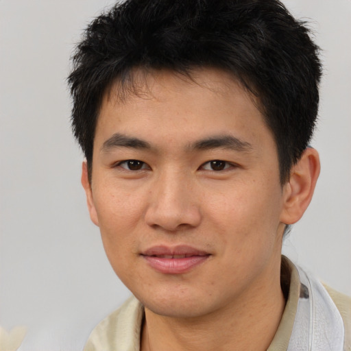 Joyful asian young-adult male with short  brown hair and brown eyes