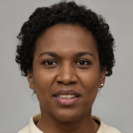 Joyful black young-adult female with short  brown hair and brown eyes