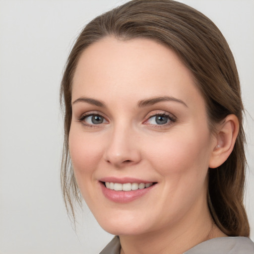 Joyful white young-adult female with long  brown hair and blue eyes