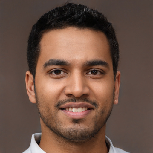 Joyful latino young-adult male with short  brown hair and brown eyes