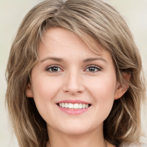 Joyful white young-adult female with long  brown hair and green eyes