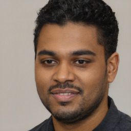 Joyful black young-adult male with short  black hair and brown eyes