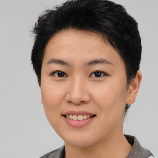Joyful asian young-adult female with short  brown hair and brown eyes