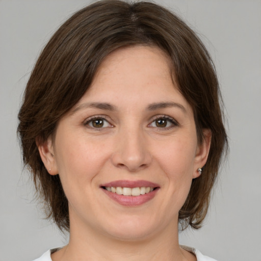 Joyful white young-adult female with medium  brown hair and brown eyes