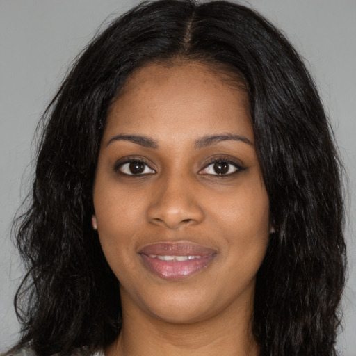 Joyful black young-adult female with long  black hair and brown eyes