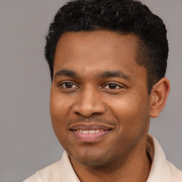 Joyful latino young-adult male with short  black hair and brown eyes