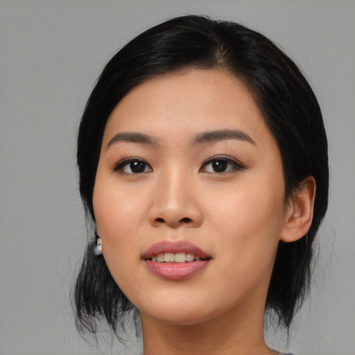 Joyful asian young-adult female with medium  black hair and brown eyes