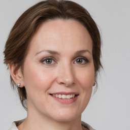 Joyful white adult female with medium  brown hair and grey eyes