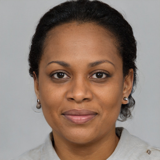 Joyful black adult female with medium  brown hair and brown eyes