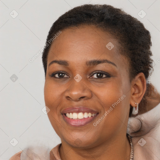 Joyful black young-adult female with long  brown hair and brown eyes