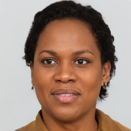 Joyful black young-adult female with short  brown hair and brown eyes