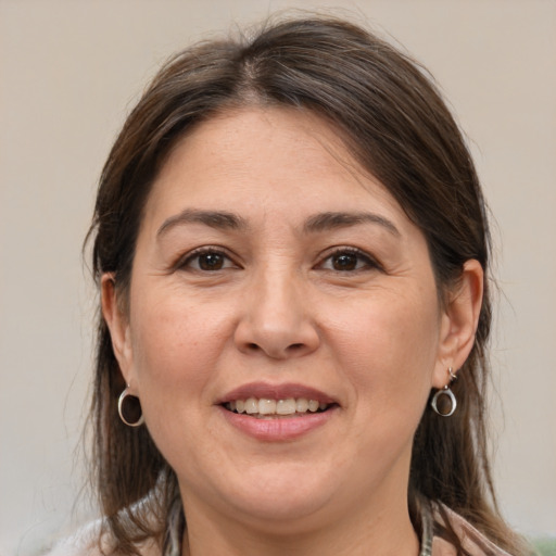 Joyful white adult female with medium  brown hair and brown eyes