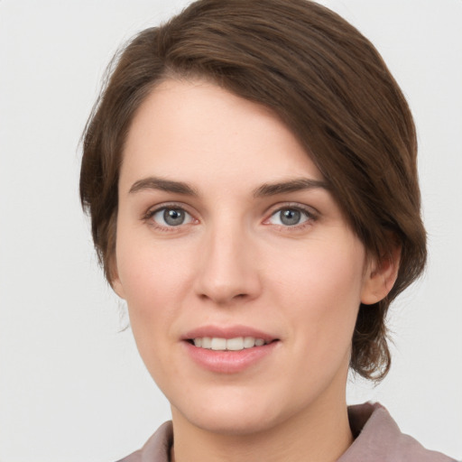 Joyful white young-adult female with medium  brown hair and grey eyes