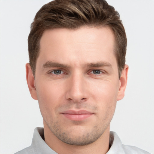 Joyful white young-adult male with short  brown hair and grey eyes