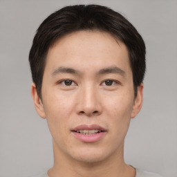 Joyful asian young-adult male with short  brown hair and brown eyes