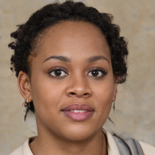 Joyful black young-adult female with short  brown hair and brown eyes